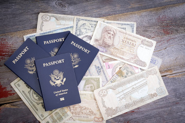 Group of American passports with foreign banknotes