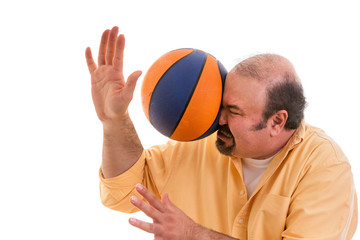 Man playing sport being hit by a basket ball