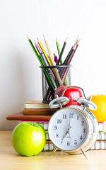 Back to school , note book , clock , pencil , apple on wood tabl