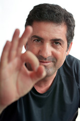 Obraz premium Mature man showing thumb Ok perfect sign.