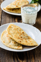 Flat bread on a plate with glass of sour milk