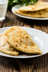 Flat bread on a plate with glass of sour milk