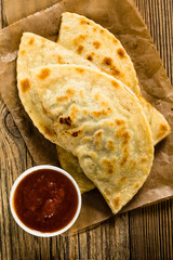 Homemade flatbread with meat, cheese, and salsa viewed from abov
