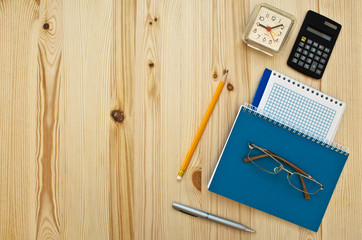 office supplies and glasses on wood background