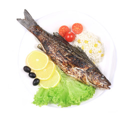 Grilled seabass on plate with vegetables.