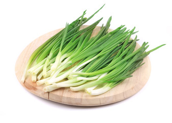 Bunch of green onion on wooden platter.