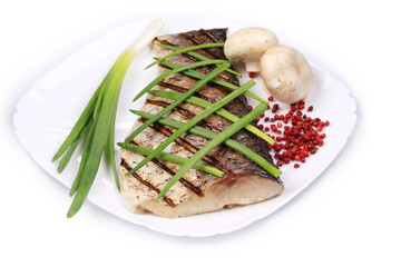 Grilled carp fillet on plate with onion.