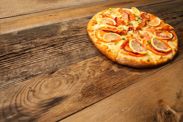 Salmone pizza on wooden table.