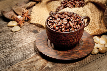 Wooden cup with coffee-beans on wooden table