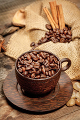 Wooden cup with coffee-beans on wooden table