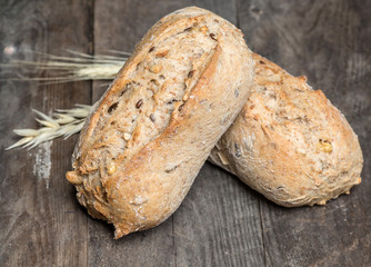 Hot and crunchy freshly baked cob of bread on old wooden table