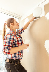 Closeup portrait of young woman aligning gypsum cardboard