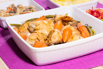 Roasted chicken, fried mushrooms, and potatoes in food trys