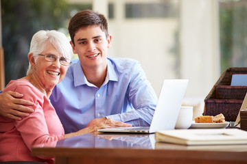 Teenage Grandson Helping Grandmother With Laptop