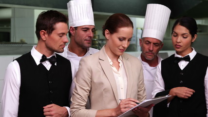Serious restaurant staff with manager looking at camera