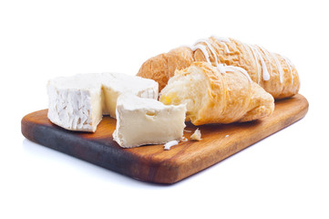 Croissant and cheese on wooden board, isolated on white
