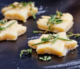 Cheese pastry dough with rolling pin on dark background