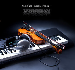 Violin, piano keys and headphones on black