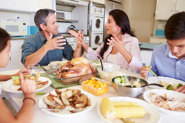 Obraz na płótnie Canvas Family Having Argument Sitting Around Table Eating Meal