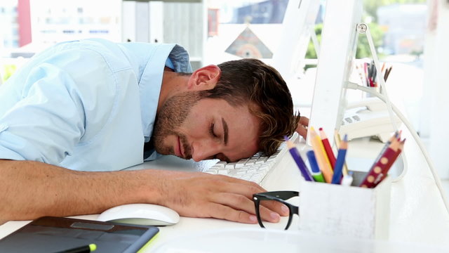 Sleepy designer falling asleep at desk