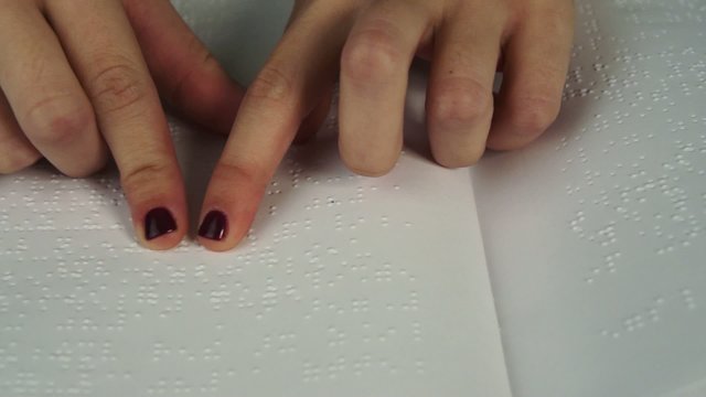 Blind woman reading text in braille language
