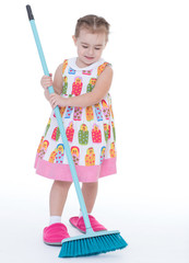 Cute little girl sweeps a floor isolated on white