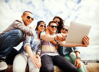 group of teenagers looking at tablet pc