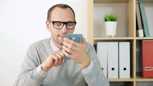 Young businessman with smartphone in the office