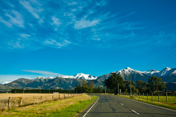 Long road stretching out to dry mountain range at Lindis Pass, t