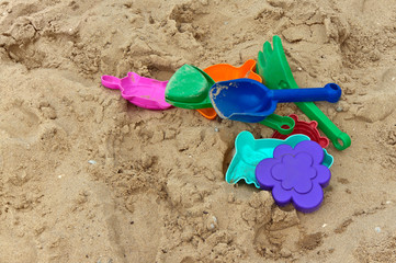 Fototapeta na wymiar Varicolored toys on the sand