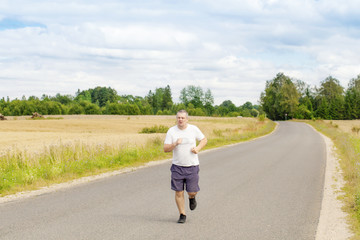 Fat man running on a rural road