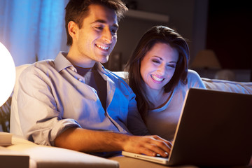 Young couple at home with laptop