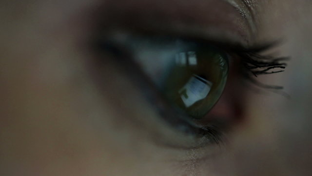 Macro shoot of woman eye looking at tablet computer
