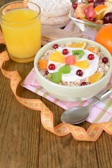 Delicious oatmeal with fruit in bowl on table close-up