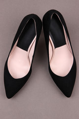 Beautiful black female shoes, on grey background