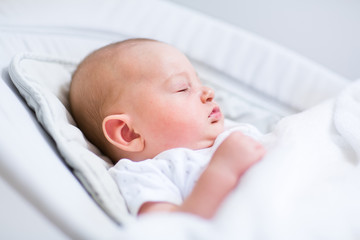 Portrait of a newborn baby sleeping in a bouncer chair