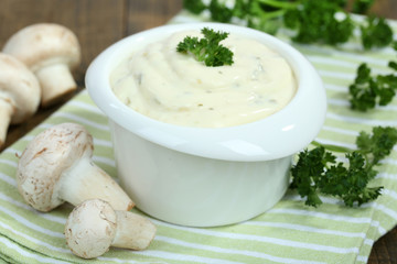 Delicate mushroom sauce in bowl on wooden table close-up