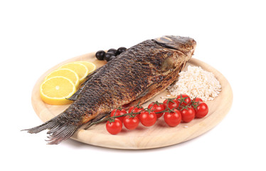Grilled carp fish with lemon and tomatoes.