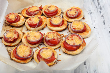 Small pizzas on baking paper close up
