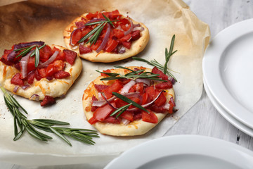Small pizzas on baking paper close up