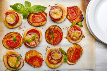 Small pizzas on baking paper close up