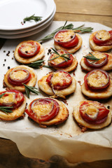 Small pizzas on baking paper close up