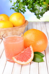 Ripe grapefruit with juice on table close-up