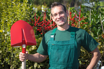 Farmer or gardener posing with shovel in garden