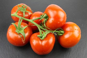 tomates en grappe sur un plateau d'ardoise