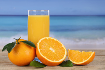 Orangensaft und Orangen am Strand im Urlaub