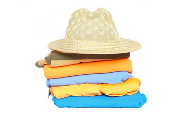 Pile of colorful clothes with a hat over white background