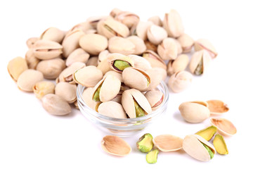 Pistachio nuts in glass bowl isolated on white