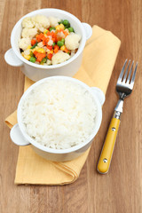 Cooked rice with vegetables on wooden table