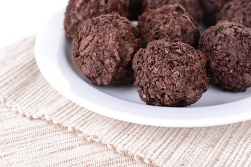 Delicious chocolates on plate close-up